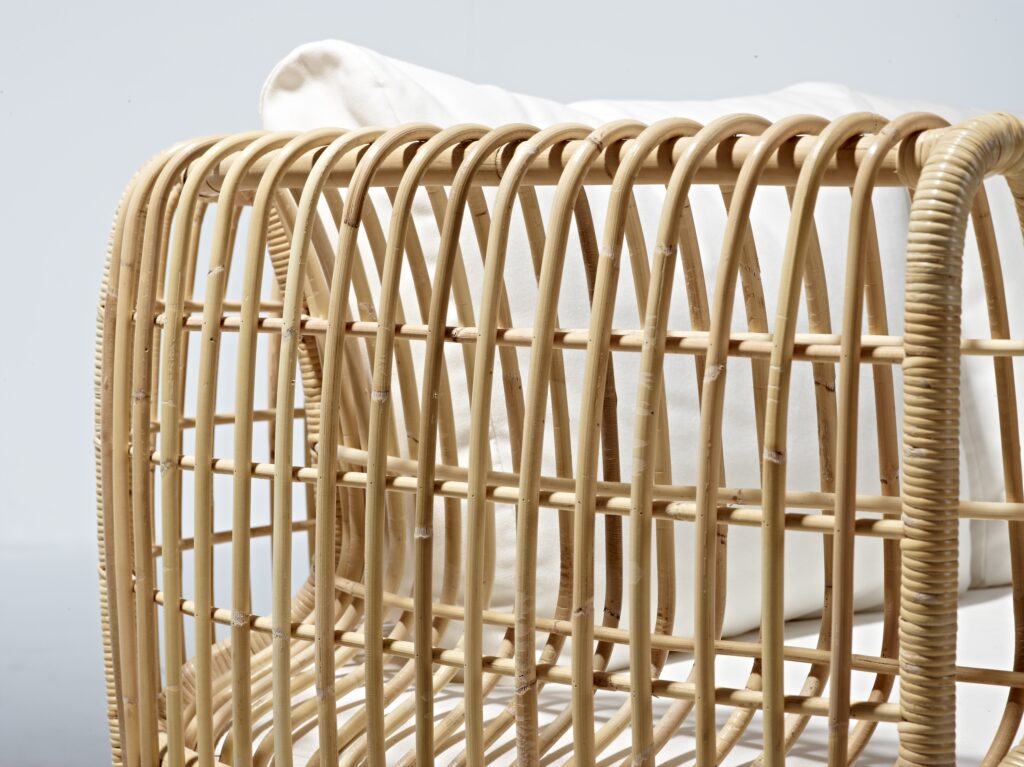 Fragment fotela rattanowe z giętych prętów i przeplatany włóknem rattanowym. Kolor rattanu miodowy.