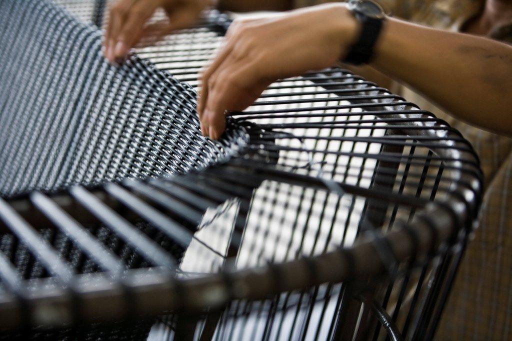 Ręce plecionkarza wyplatające mebel ogrodowy z włókna Cane-line Weave