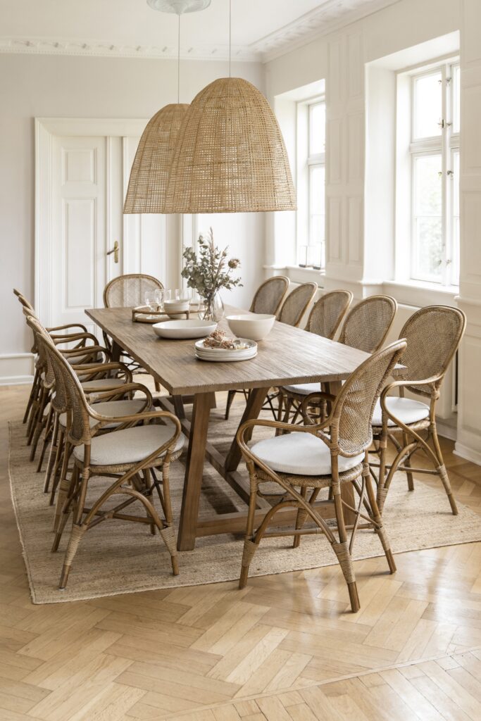 jadalnia z dużym stołem teakowym i dwunastoma krzesłami z rattanu Rossini, na stołem dwie duże lampy z rattanu