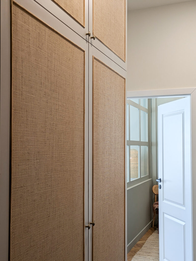 Zbliżenie na szafę w przedpokoju oklejoną tapetą z plecionki papierowej