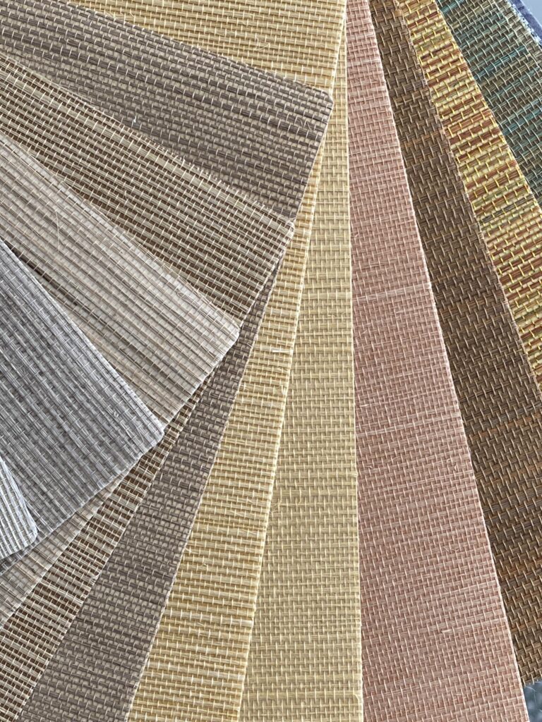 Widok z góry na rozłożony w wachlarz wzornik tapet z sizalu, różne kolory