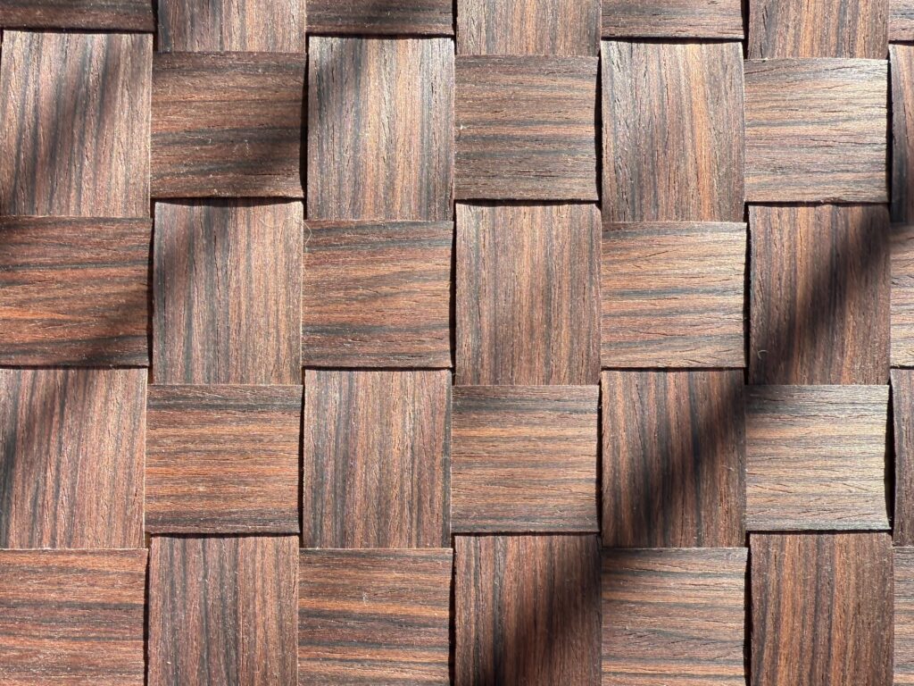 zbliżenie na fragment ściany z ręcznie wyplatanego forniru, kolor brązowy, splot- kratka