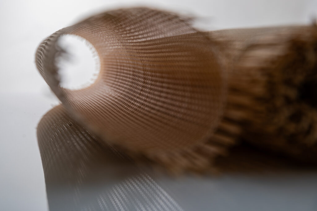 artystyczne zdjęcie plecionki meblowej, obraz rozmyty, światło prześwieca przez plecionkę