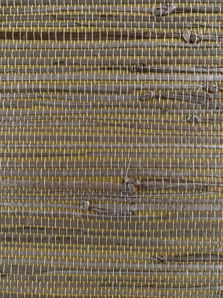 zbliżenie na tapetę z trawy morskiej, widoczne zgróbienia i wiązania trawy morskiej oraz nitki montażowe różne odcienie kolorów żółtego i beżu