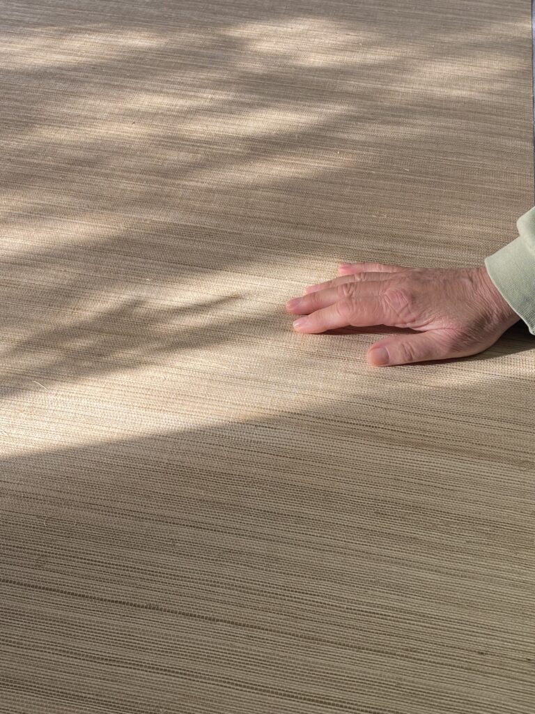 Tapeta z sizalu GOBI jest dotykana dłonią