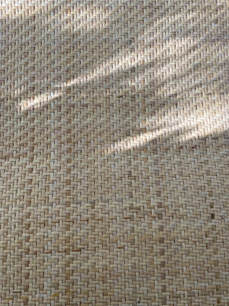 zbliżenie na plecionkę rattanową z cieniami i plamami światła