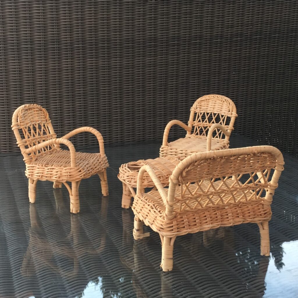 zbliżenie na miniatury mebli z rattanu, kolor ecru. komplet 2 foteli, sofy i stolika.