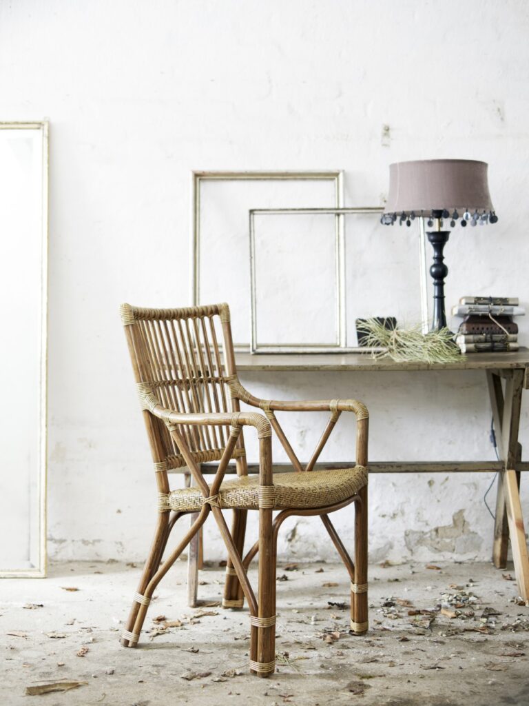 Krzesło rattanowe Piano stoi w rustykalnym pomieszczeniu