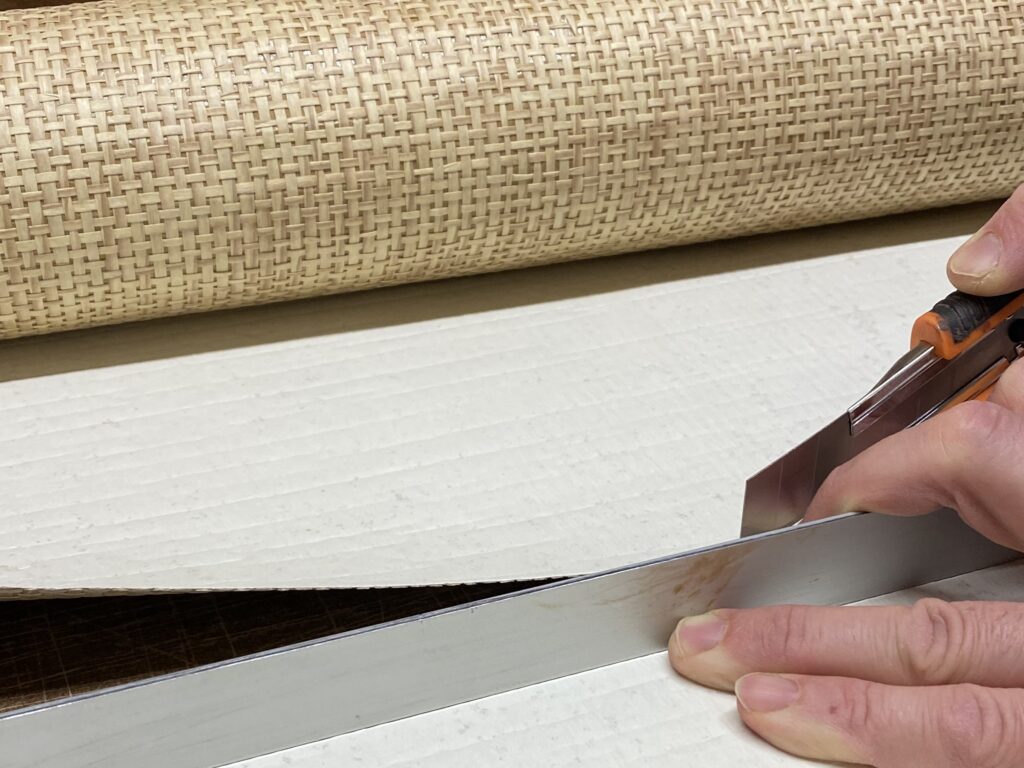 Docinanie tapety z plecionki papierowej ostrym nożykiem