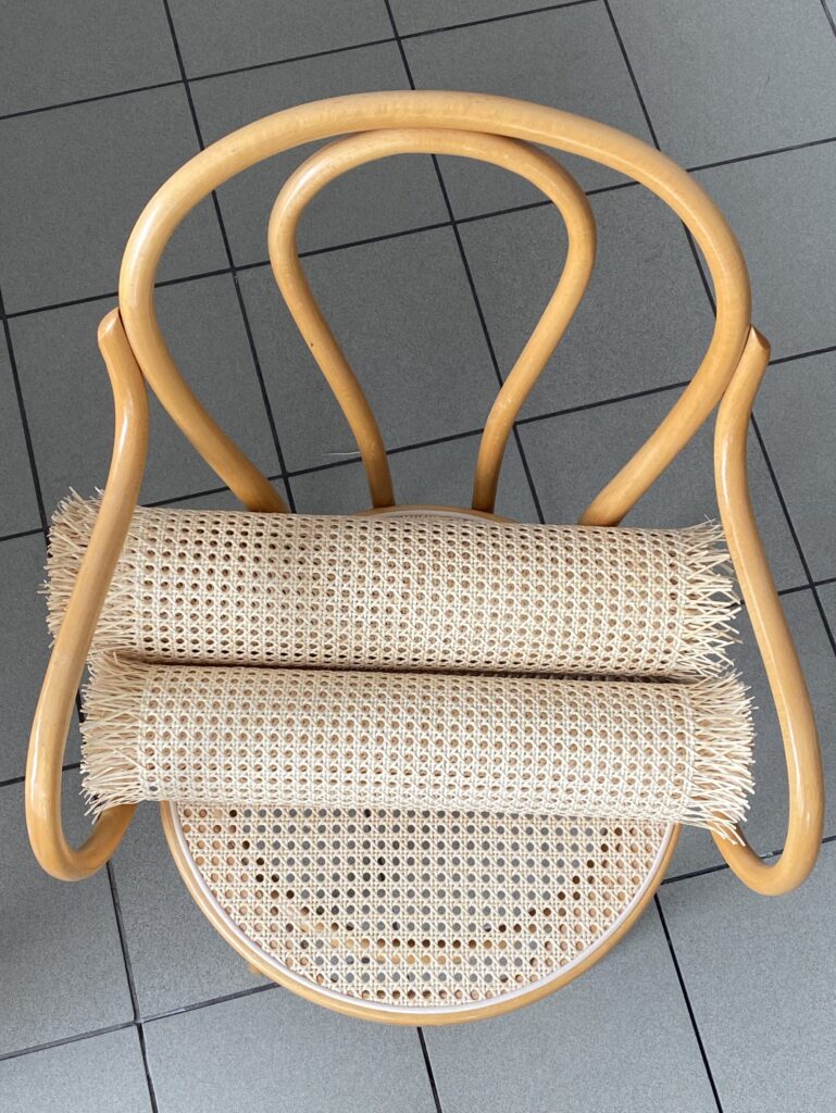 widok z góry: krzesło gięte z siedziskiem z plecionki rattanowej, na siedzisku leżą dwie rolki siatki rattanowej