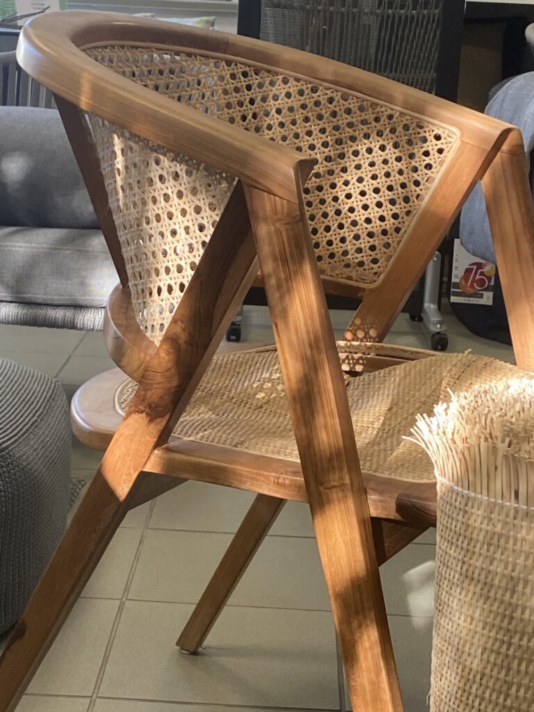 Zbliżenie na uszkodzone siedzisko z plecionką rattanową, na pierwszym planie rolka maty rattanowej