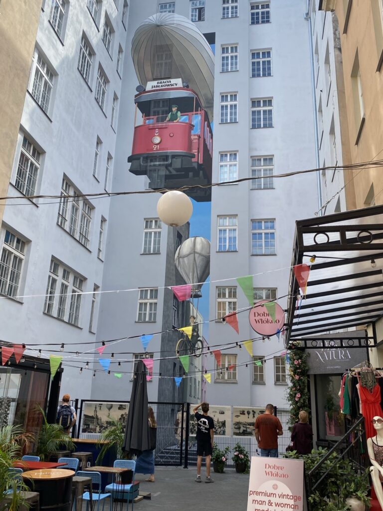 Latający czerwony tramwaj na muralu „Warszawa w przyszłości” przy Chmielnej 21 w Warszawie